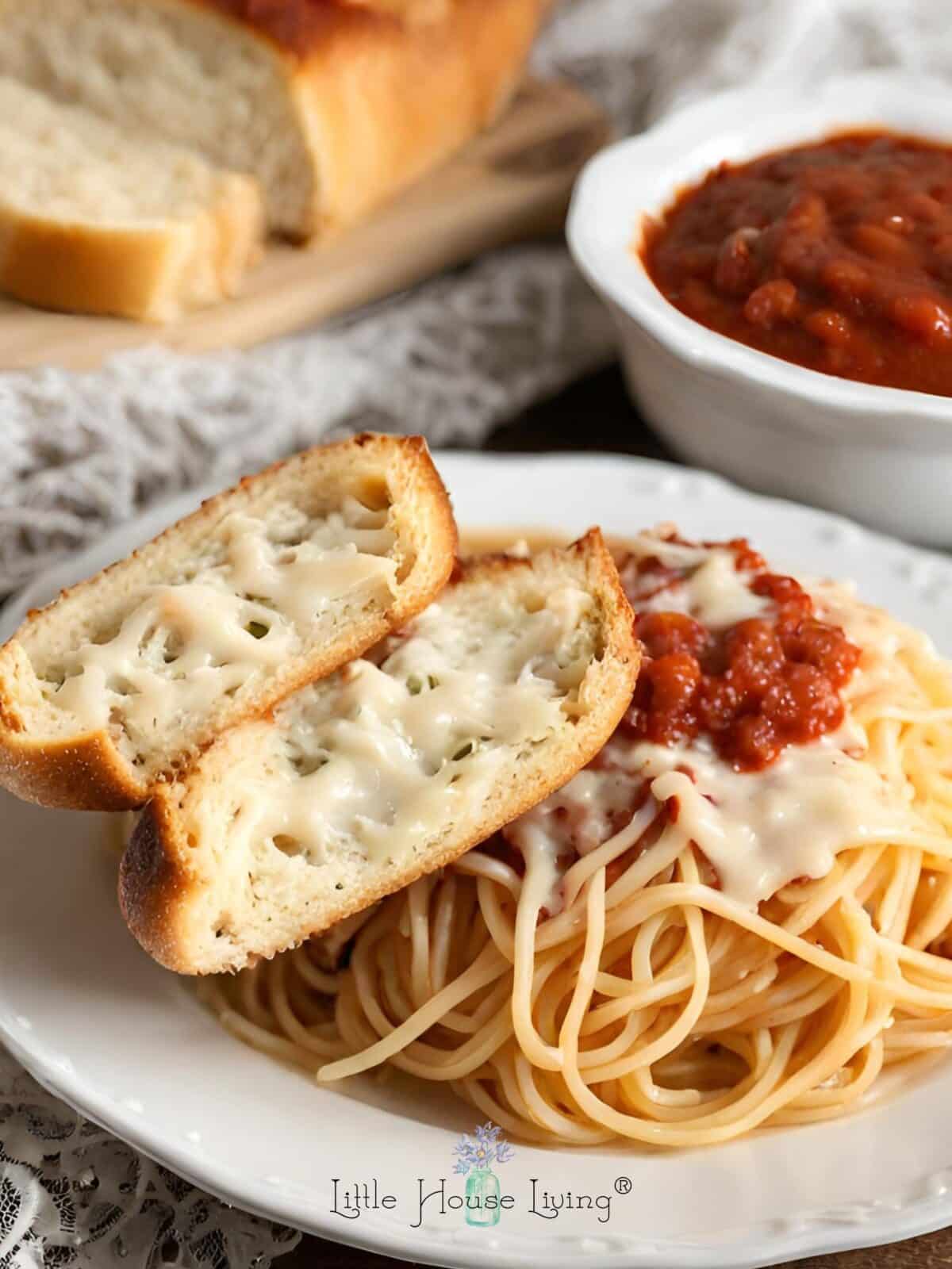 Cheesy French bread on top of spaghetti.