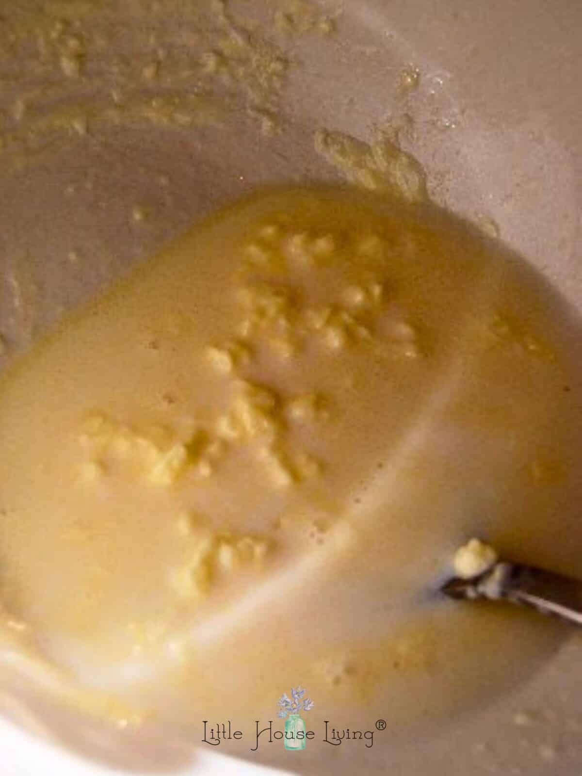 Melted butter and milk in a white bowl.