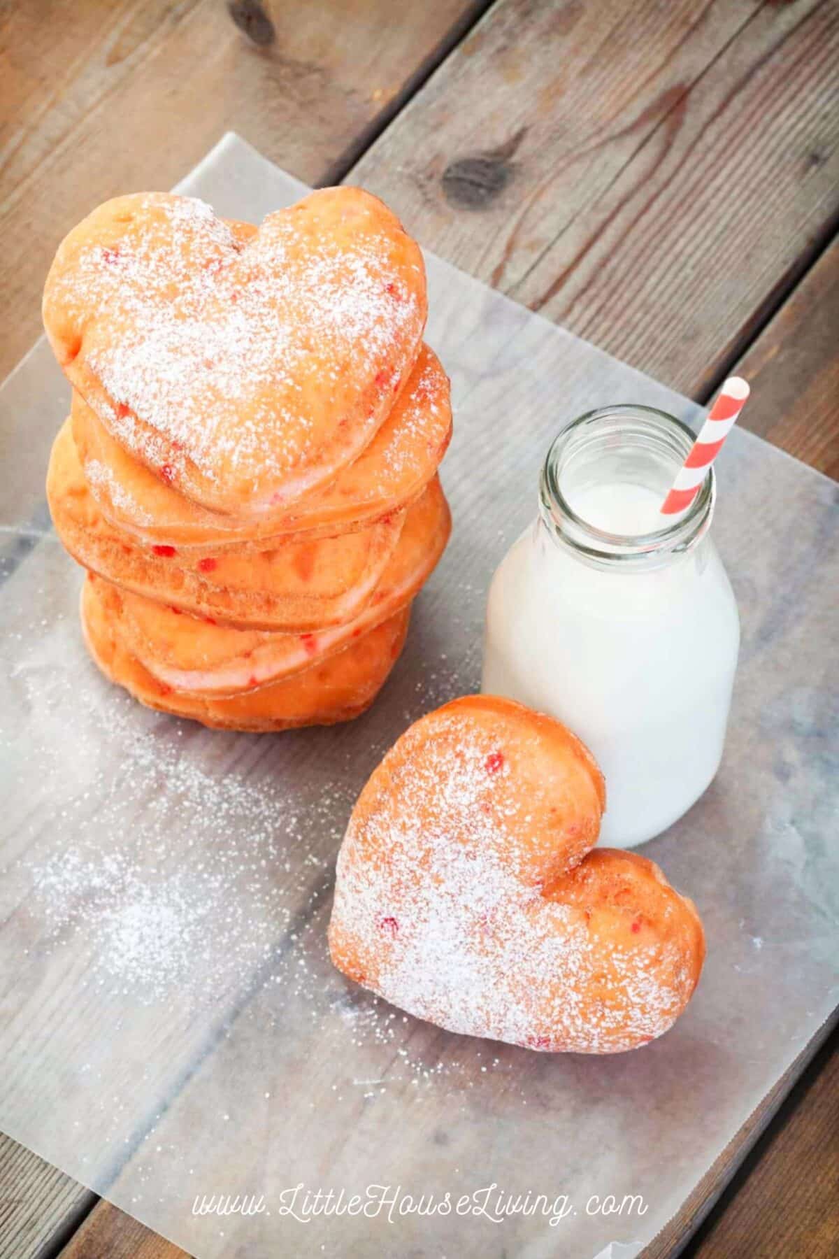 Heart shaped doughnuts with a glass of milk.