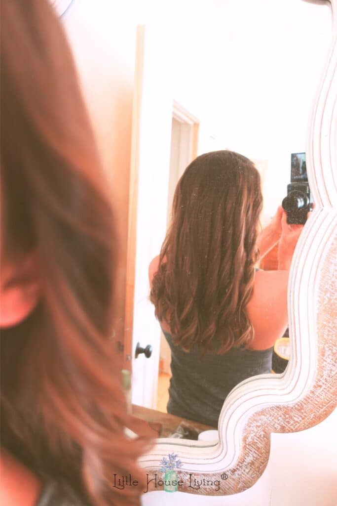 Merissa with a camera showing her hair in a mirror.