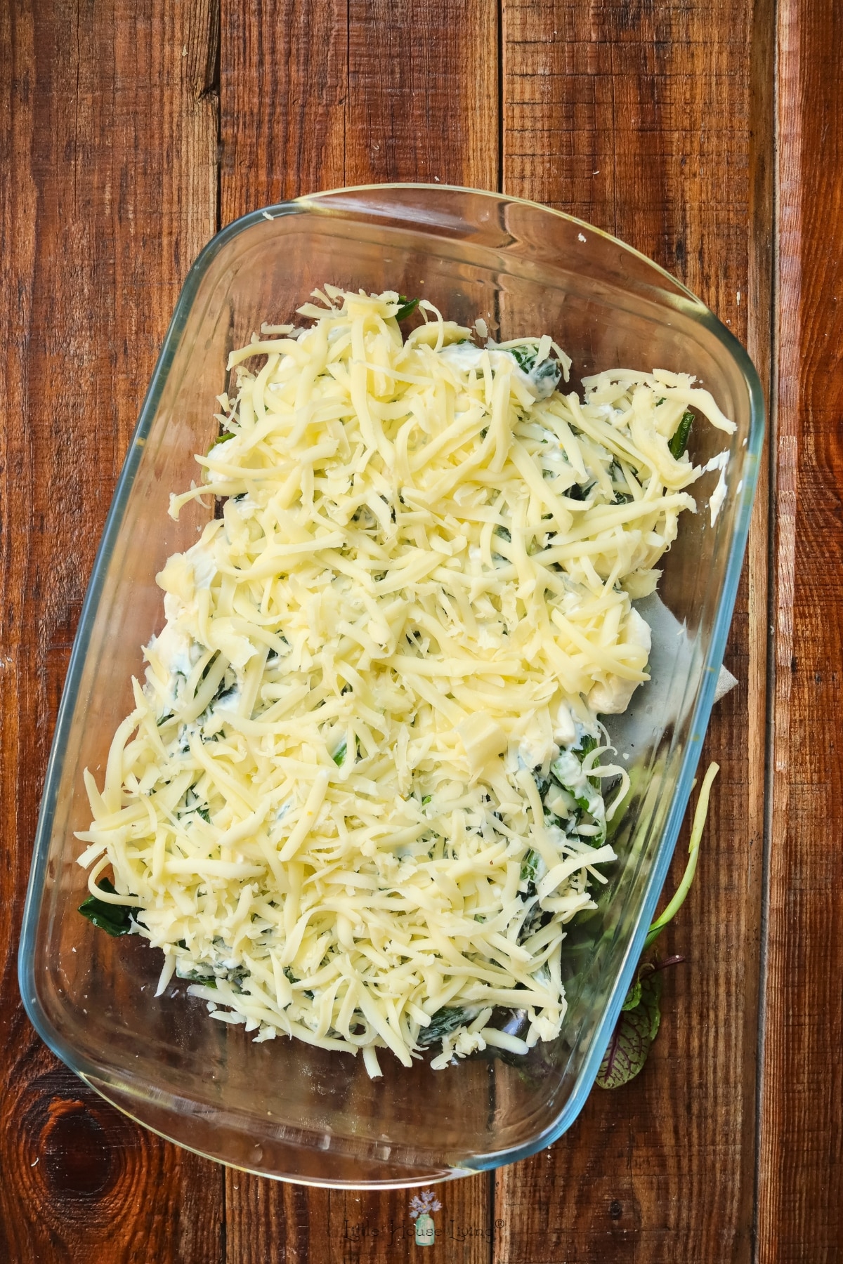 cream cheese spinach dip topped with cheese and ready to bake