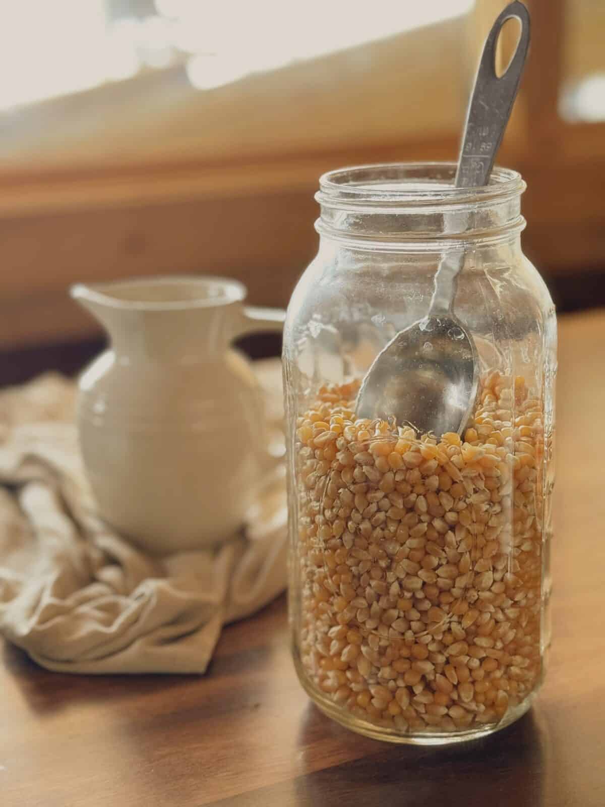 jar of popcorn with a measuring spoon in it