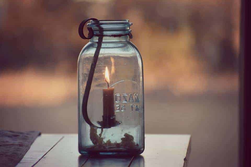 candle in jar on table